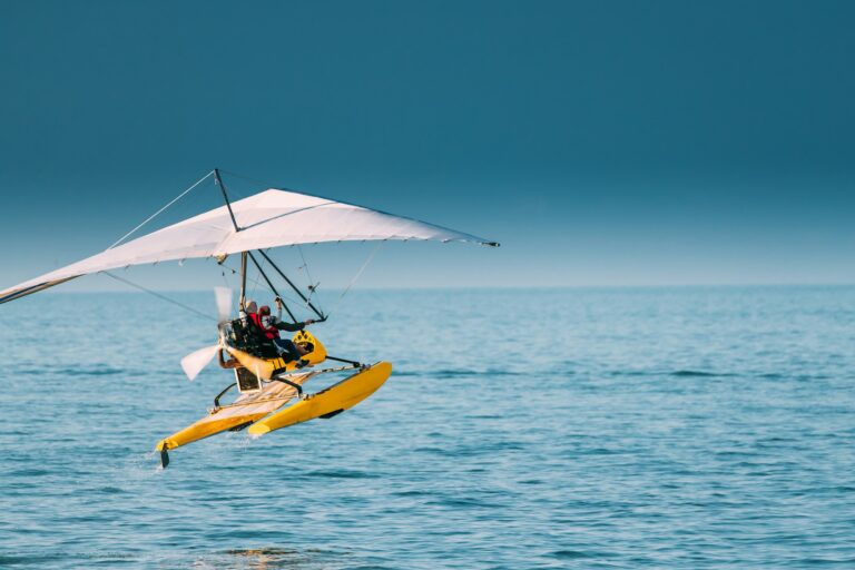 Motorized Hang Glider With Muslim Woman Take Off Frow Sea In Sun