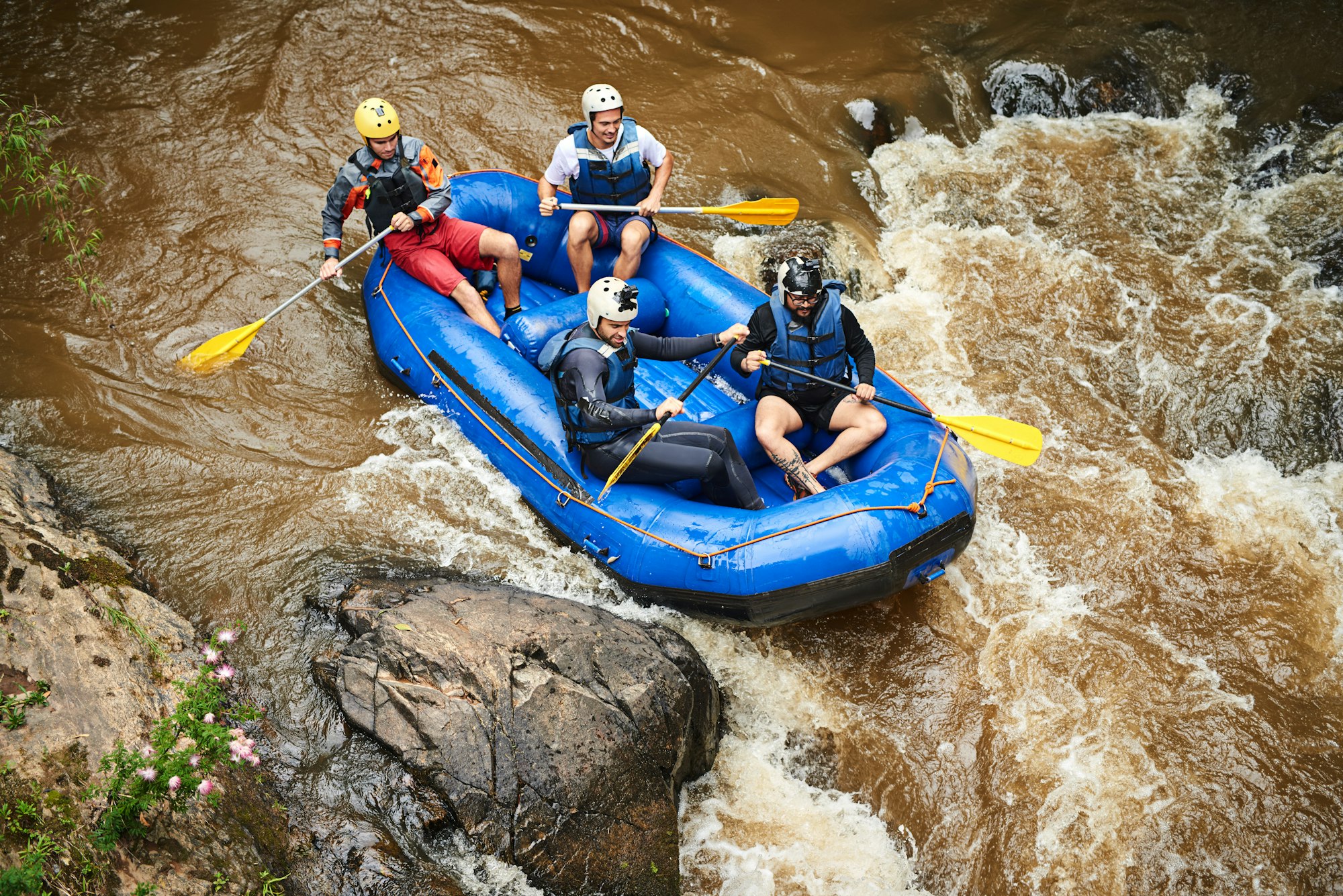 Through the rapids. High angle shot of a group of young friends white water rafting.